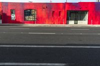 red building with graffiti on the wall next to a street with two fire hydrants