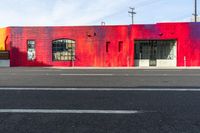 red building with graffiti on the wall next to a street with two fire hydrants