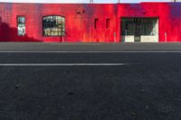 red building with graffiti on the wall next to a street with two fire hydrants