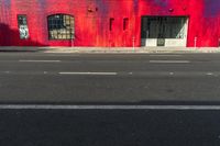 red building with graffiti on the wall next to a street with two fire hydrants