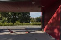 a park bench in front of a building that is painted red and has several mirrors on it