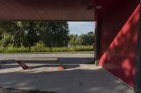 a park bench in front of a building that is painted red and has several mirrors on it