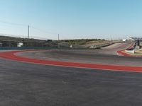 an empty track at a motorsports club with some red and white stripeing on it