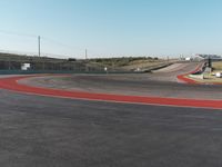 an empty track at a motorsports club with some red and white stripeing on it