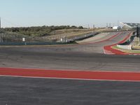 an empty track at a motorsports club with some red and white stripeing on it