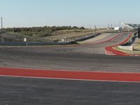 an empty track at a motorsports club with some red and white stripeing on it