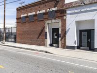 a red fire hydrant next to a brick building on the corner of a street