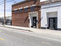 a red fire hydrant next to a brick building on the corner of a street