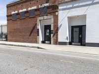 a red fire hydrant next to a brick building on the corner of a street