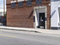 a red fire hydrant next to a brick building on the corner of a street