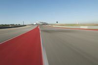 a motorcyclist rides the red line of a road, as viewed from the perspective of the driver