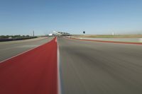 a motorcyclist rides the red line of a road, as viewed from the perspective of the driver