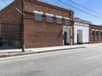 a red motorcycle sitting outside an old, run down building with a street behind it