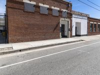 a red motorcycle sitting outside an old, run down building with a street behind it