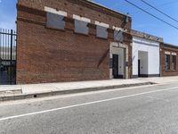 a red motorcycle sitting outside an old, run down building with a street behind it