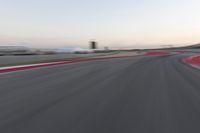 Red Race Car Speeds Down a Winding Road