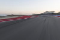 Red Race Car Speeds Down a Winding Road