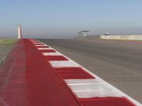 an empty track at a motorsports club with some red and white stripeing on it