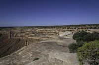 an arid plain covered with rocks and water, with small vegetation on the side of it