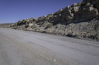 a dirt road with rocks on the side and a motorcycle parked at the end in the center of it