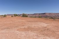 a very dry, arid ground in the desert with rocks and trees nearby for background