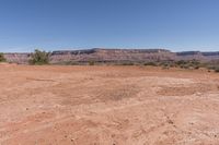 a very dry, arid ground in the desert with rocks and trees nearby for background