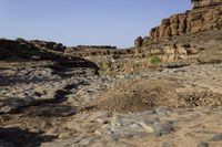 a rocky terrain features pebbles, some green and others gray as it stands against the sky