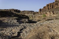 a rocky terrain features pebbles, some green and others gray as it stands against the sky