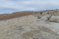 the person is on a motorcycle in the mountains in a desert area of rock formations