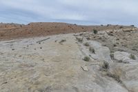 the person is on a motorcycle in the mountains in a desert area of rock formations