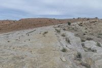 the person is on a motorcycle in the mountains in a desert area of rock formations