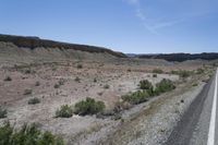 the desert has a mountain and brush growing on it's sides in front of it