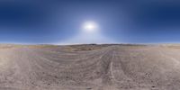 a desert is in the background with a bright sun shining over it, from a fish - eye lens