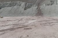 some sand mountains and hills and the sky with clouds above it, and there are no leaves on the ground