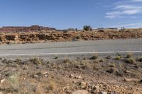 a long road stretches through a desert area with mountains in the background and a desert landscape in the foreground