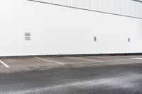 a red stop sign sitting next to a white building with parking spaces on the side