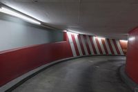 red and white wall by the road inside a tunnel with light on it's top
