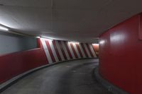red and white wall by the road inside a tunnel with light on it's top