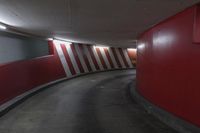 red and white wall by the road inside a tunnel with light on it's top