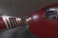 red and white wall by the road inside a tunnel with light on it's top