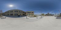 this is a reflection of a building in an outdoor skating park taken with a fish eye lens