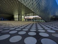 many circles sit in the center of the building at dusk, reflecting light from the windows