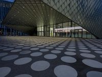 many circles sit in the center of the building at dusk, reflecting light from the windows