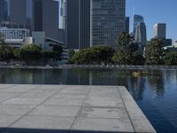 the reflection of buildings in water is shown on the ground next to an open area with water and benches