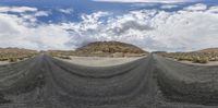 a view of a road in the middle of nowhere with no people around it and mountains, like a desert