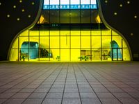 an empty terminal entrance with no people or luggage at night, glowing off the windows