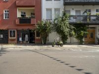 an apartment building with a balcony above a street on the side of the road in front of it