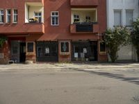 an apartment building with a balcony above a street on the side of the road in front of it