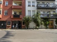 an apartment building with a balcony above a street on the side of the road in front of it