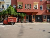 an apartment building with a balcony above a street on the side of the road in front of it